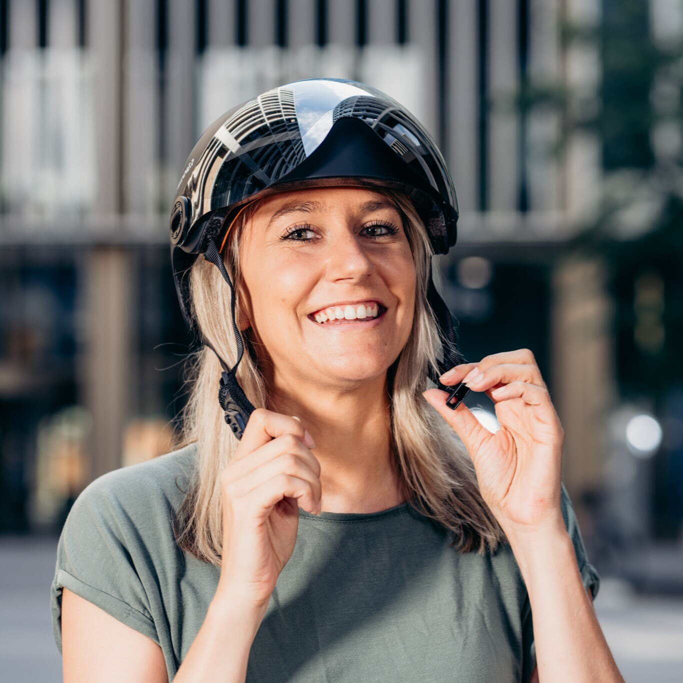 Eine Frau zieht sich einen Fahrradhelm an