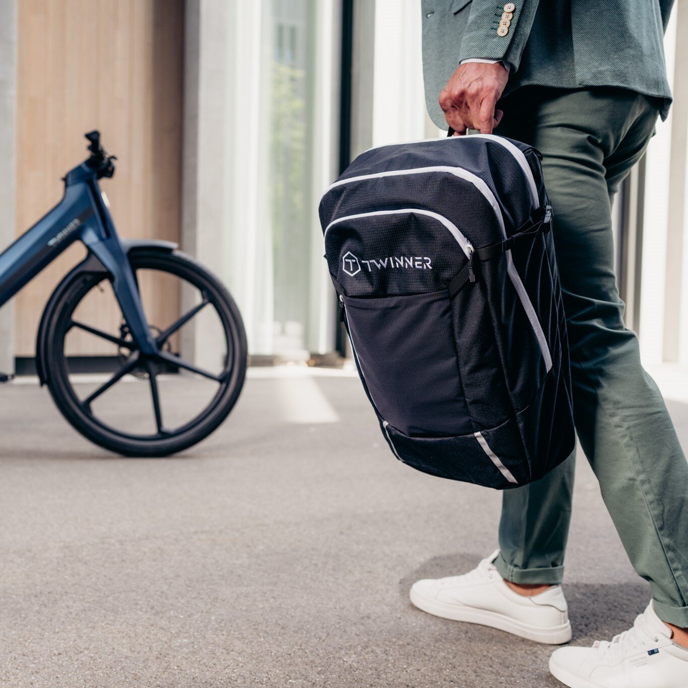 Mann mit Rucksack in der Hand geht auf sein Twinner E-Bike zu