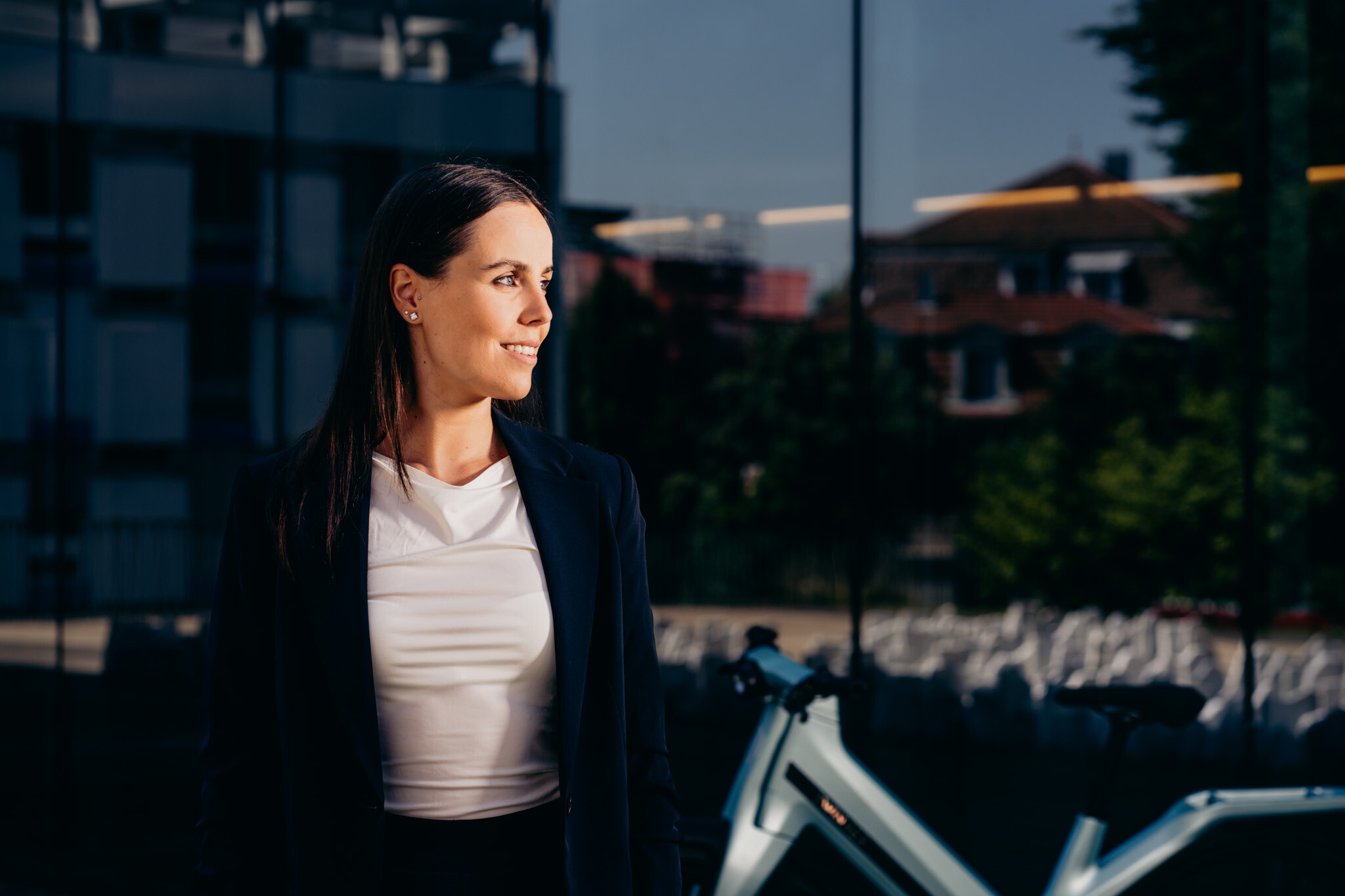 Frau vor modernem urbanen Gebäude mit einem Twinner E-Bike